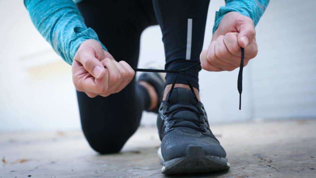 Ein Mann bindet sich die Laufschuhe